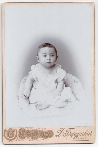 Portret brzdąca, białe wdzianko, bose stópki, siedzący Fotografia na kartoniku firmowym Odessa [1900]