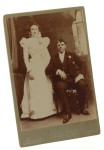 Portret młodej pary, strój ślubny, mężczyzna siedzi Fotografia na tekturce firmowej / albumin (Dayton ca 1900 Bowersox)