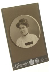 Portret kobiety, popiersie w okręgu, włosy upięte, suknia biała, aksamitka na szyi Fotografia na tekturce firmowej / odbitka srebrowożelatynowa (Kijów ca 1900 N. Ouzemsky)