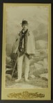 Portret młodego mężczyzny w stroju góralskim, kapelusz, cucha, kubrak, koszula, portki, kierpce, ciupaga Fotografia na tekturce / odbitka srebrowożelatynowa (ca 1900)