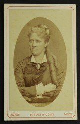 Portret kobiety, podkrążone smutne oczy, które dużo widziały, kolczyki, loki, upięcie ozdobione kwiatem Fotografia na tekturce /albumin [Rivoli & Comp/ Poznań ca 1880] 