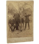 Portret-mezczyzn-w-plenerze,-dwoch-siedzi,-dwoch-stoi,-jeden-w-stroju-mysliwego,-z-dwururka-Fotografia-na-tekturce-firmowej--albumin-Halle-ca-1900-Josef-Weissgerber.jpg
