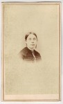 ​Portret kobiety - popiersie, brosza, kolczyki, włosy gładko zaczesane Fotografia na kartoniku firmowym ca. 1900 / USA