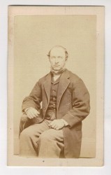 Portret mężczyzny - siedzący, broda, prawa ręka spoczywa na poręczy krzesła Fotografia na kartoniku firmowym ca. 1900 / USA