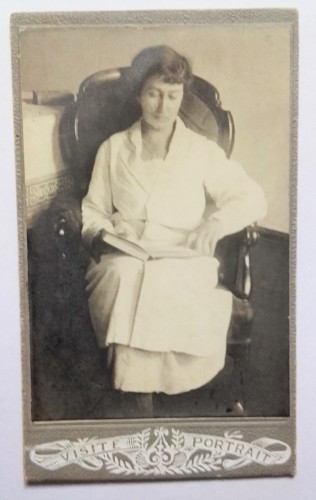 Portret kobiety - siedzący, otwarta książka na kolanach Fotografia na kartoniku ca. 1900