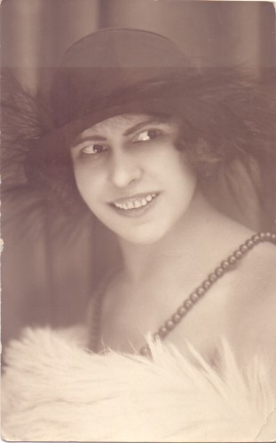 Portret kobiety w kapeluszu z piórami i naszyjniku z pereł  [fotografia na papierze pocztówkowym] [przed 1945 r.]